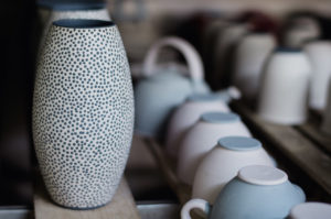 Row of ceramic vases and teapots with a modern, minimalist design in soft pastel colors at Adagio Villa Resort.