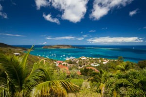 Stunning panoramic view of turquoise waters, sailboats, and lush greenery from a high vantage point at Adagio Villa Resort.