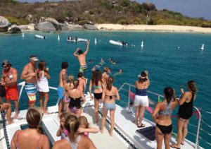 Group of people on a catamaran cruise, enjoying the ocean and beach activities at Adagio Villa Resort.