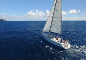 Sailors enjoying a scenic voyage on a white sailing yacht with billowing sails at Adagio Villa Resort.