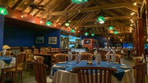Cozy indoor dining room with wooden ceiling, blue walls, and tables set for a meal at Adagio Villa Resort.